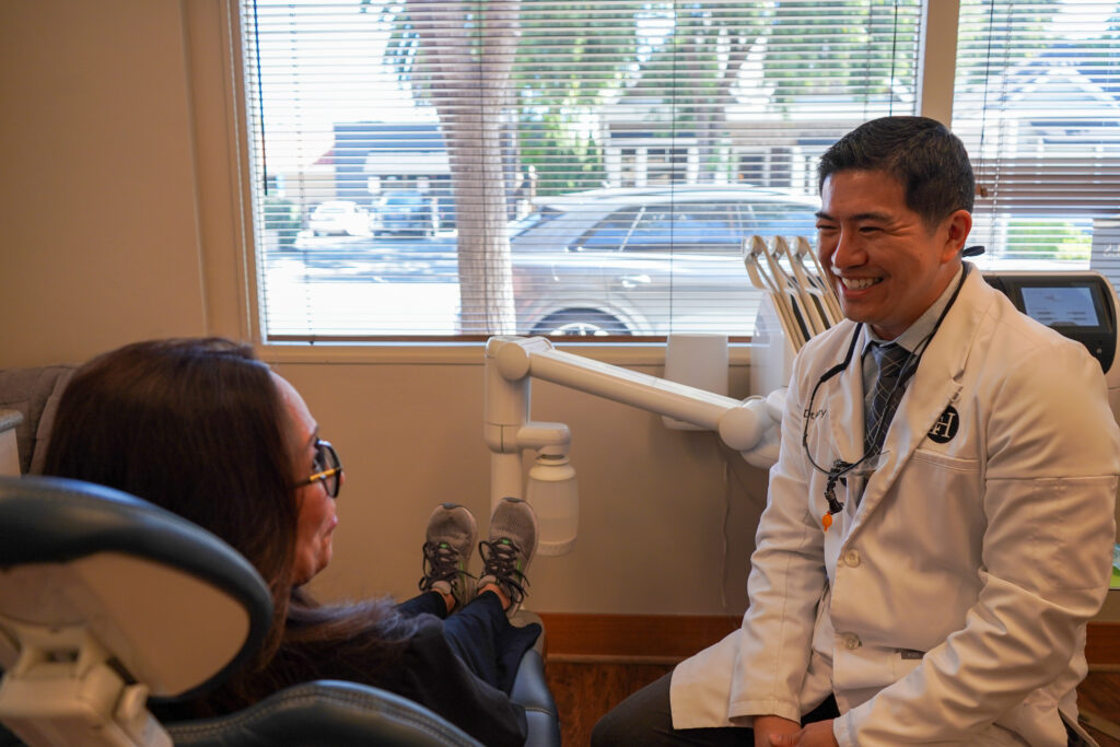 Dr. Harry Tseng smiling during a comfortable, personalized patient consultation in his Palo Alto office.