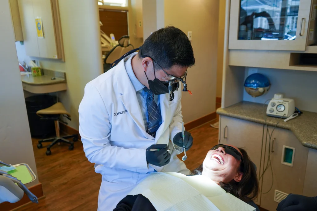 Dr. Harry Tseng evaluating a patient's custom porcelain veneer alignment during a cosmetic smile makeover in Palo Alto.